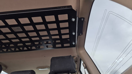Black metal grid attached to a vehicle's interior ceiling