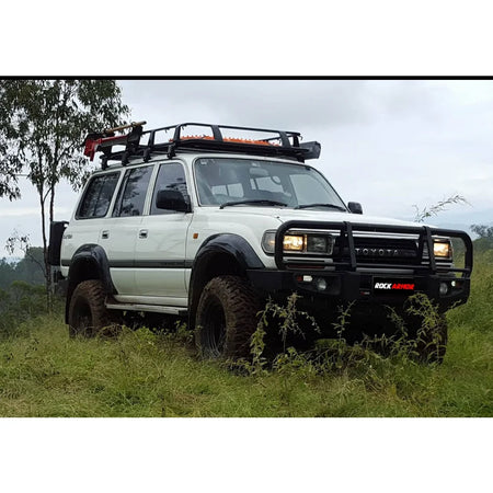 White toyota landcruiser fj80 with rockarmor premium steel bullbar and roof rack featuring led fog lights